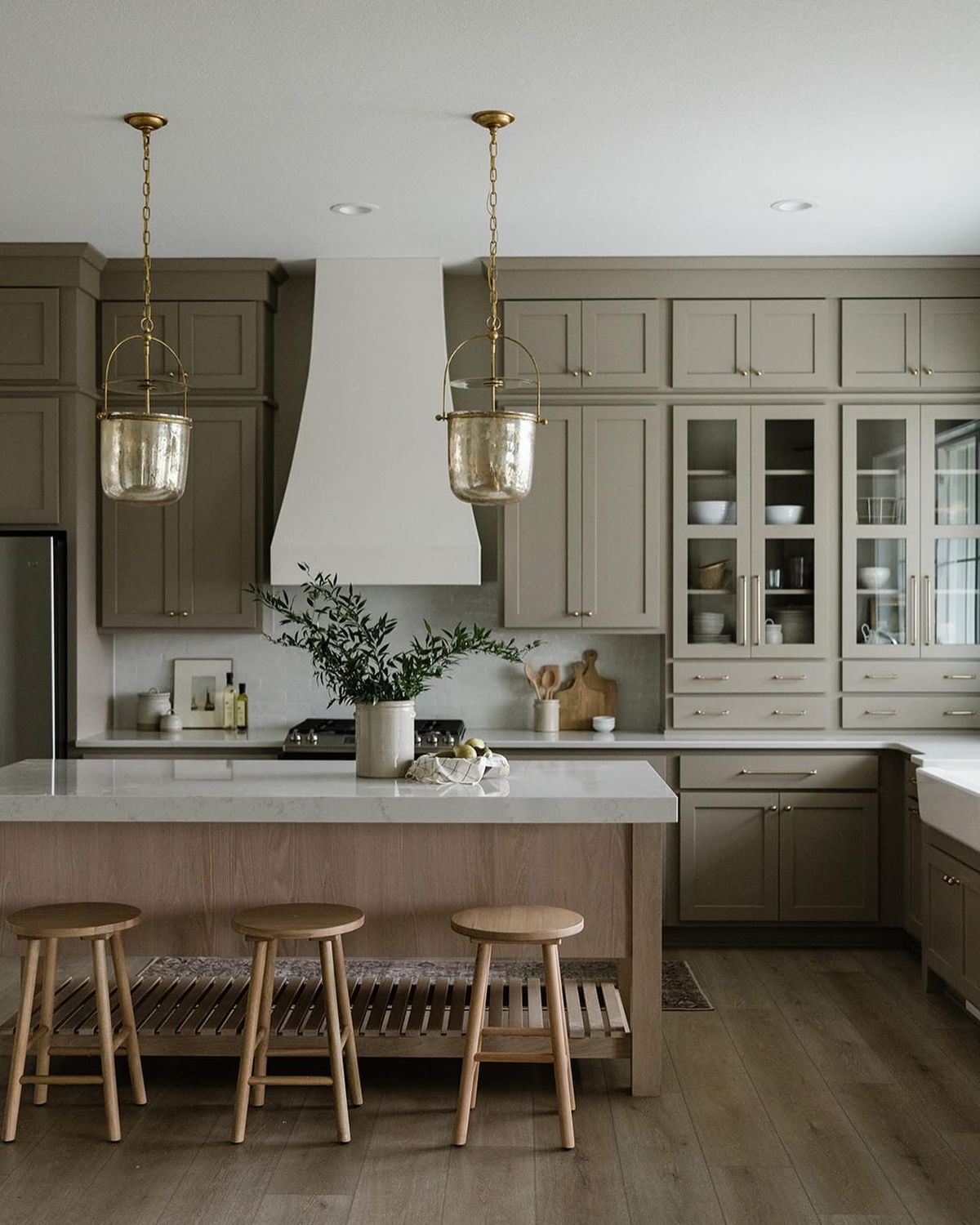 taupe shaker kitchen cabinets with wood island and brass pendant lighting