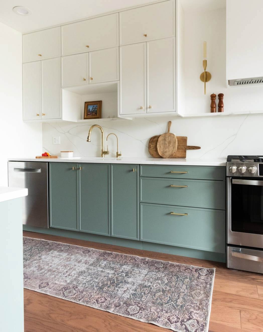 Two-tone slim shaker cabinets with white upper cabinets and soft green lower cabinets, brass hardware, and modern kitchen design.