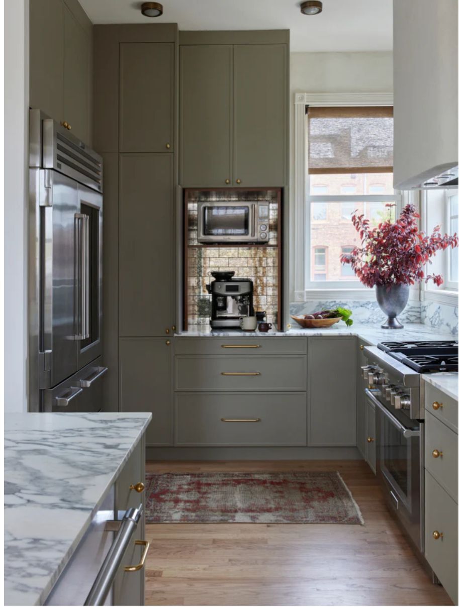 Muted olive slim shaker cabinets with built-in coffee station, marble countertops, and brass hardware in a modern kitchen.
