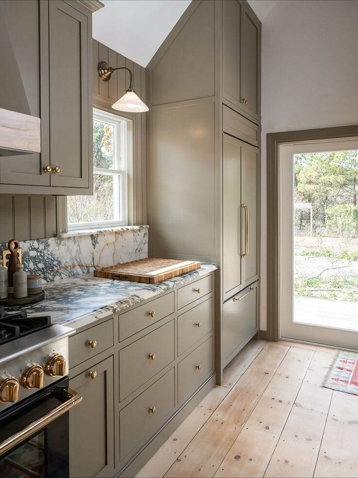 olive taupe shaker kitchen cabinets with marble backsplash and brass hardware