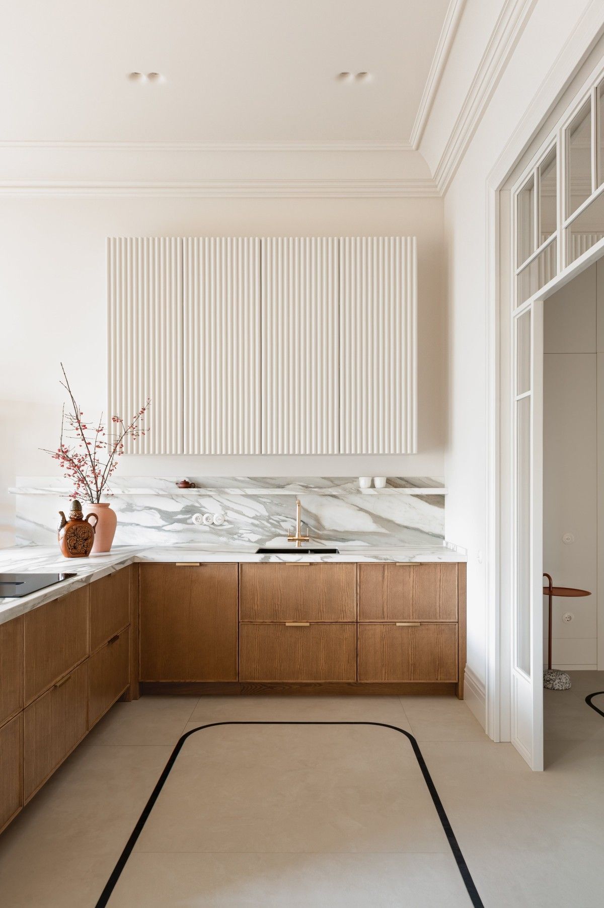 Slim shaker wood base cabinets with fluted upper cabinet panel, marble backsplash, and modern minimalist kitchen design.