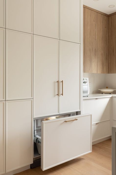 Slim shaker cabinets with hidden pull-out storage, neutral kitchen design, and modern custom cabinetry details.