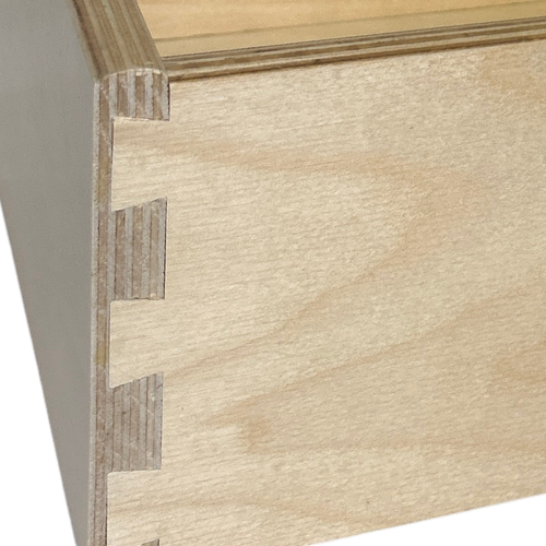 Close-up of a 9-ply Baltic birch drawer box corner showing precision-cut dovetail joinery and multi-layer plywood construction for strength and durability.