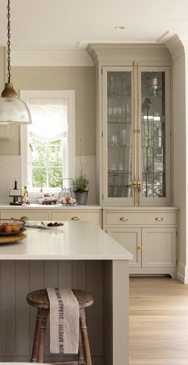 cream shaker kitchen cabinets with glass display hutch and brass hardware