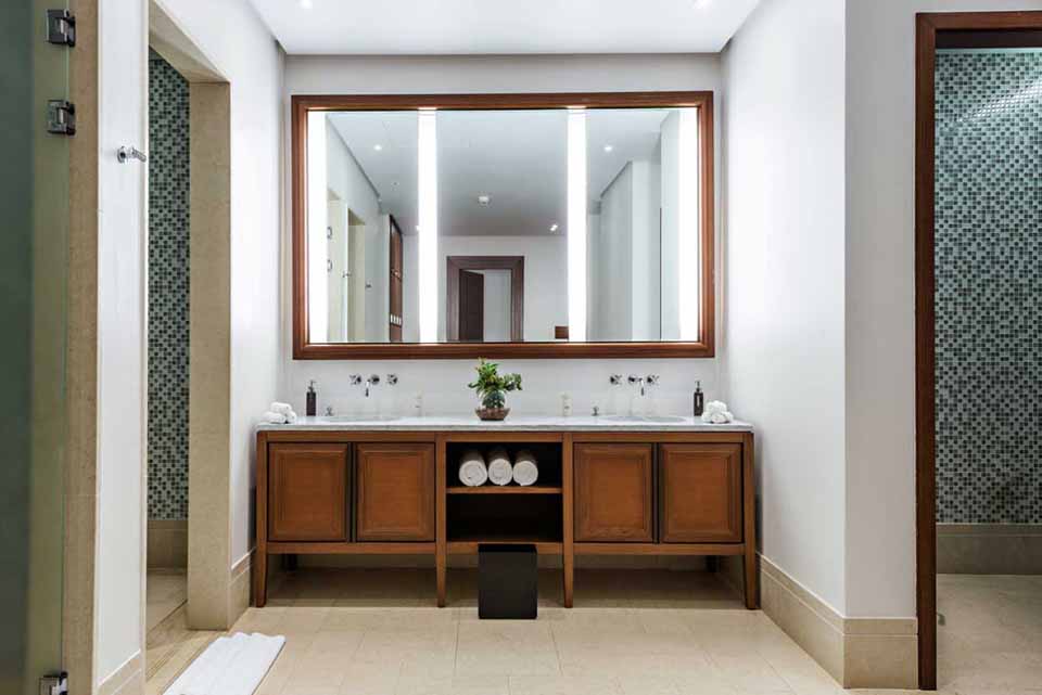 A bathroom with a large mirror over the vanity.