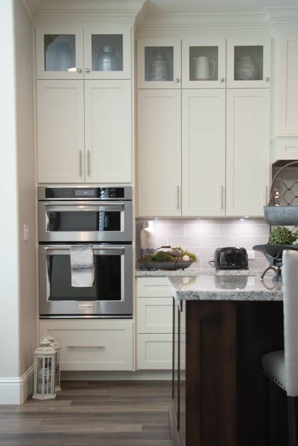 A kitchen with glass panel upper display cabinets in the shaker style.