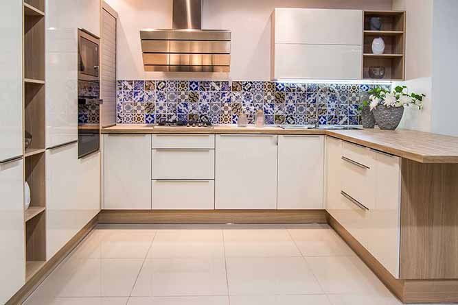 A small U-shaped kitchen layout with slab style cabinets and a decorative tile backsplash
