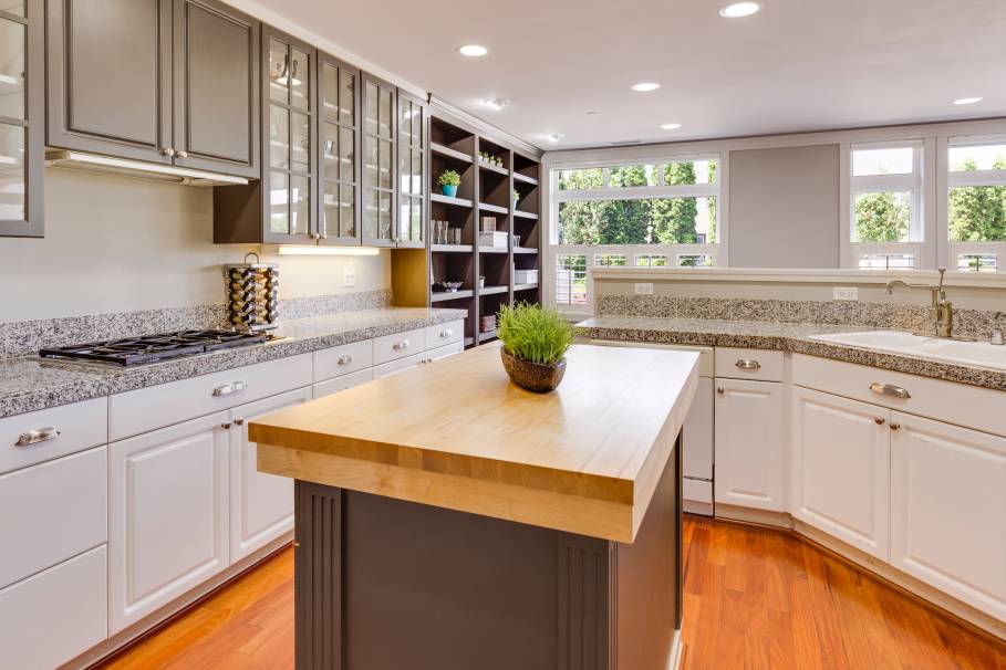 Large bright kitchen with glass cabinet doors. 