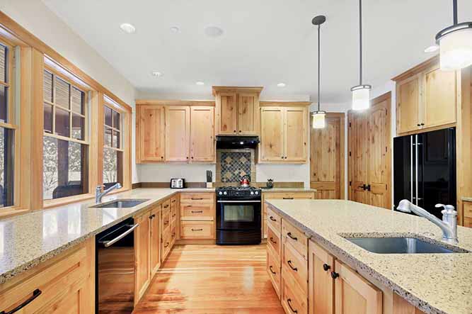 A large, traditional kitchen with natural finish shaker cabinets.