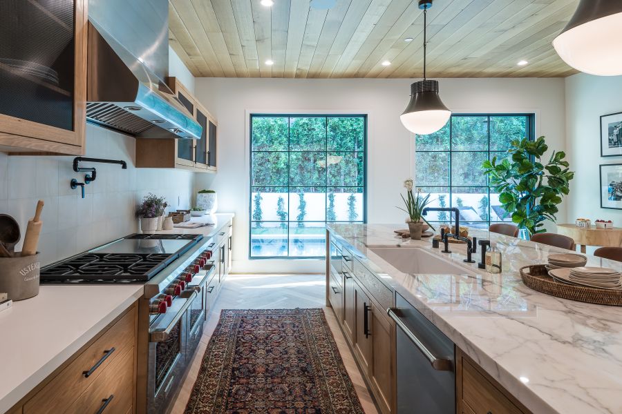 A kitchen island with a sink facing a wall of cabinet doors and drawers.