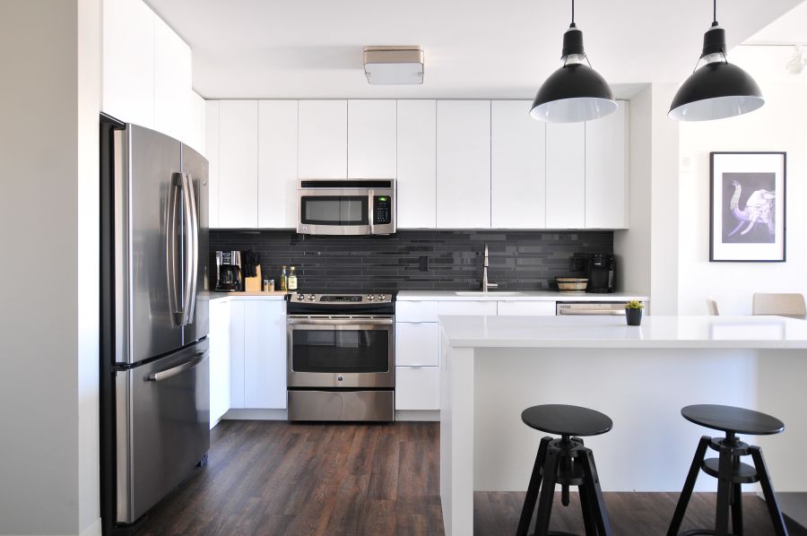 A modern L-shaped kitchen with thermofoil cabinets.