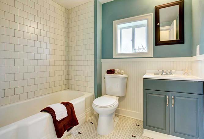 A small bathroom with a framed bathroom mirror.