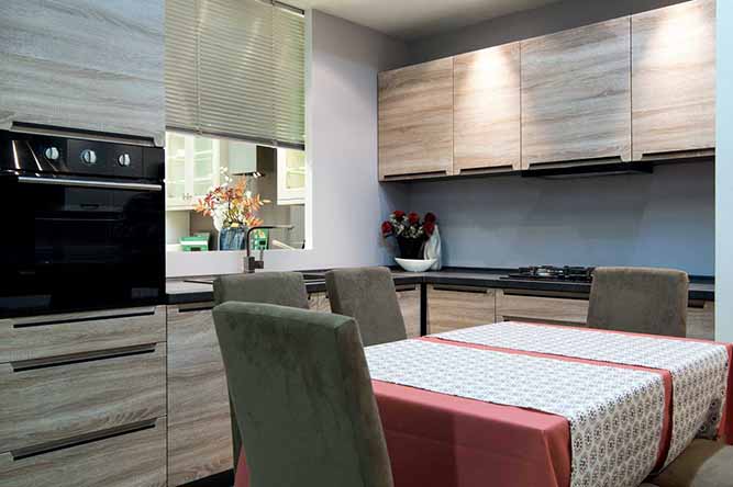 A small, modern kitchen with slab-style thermofoil cabinets.