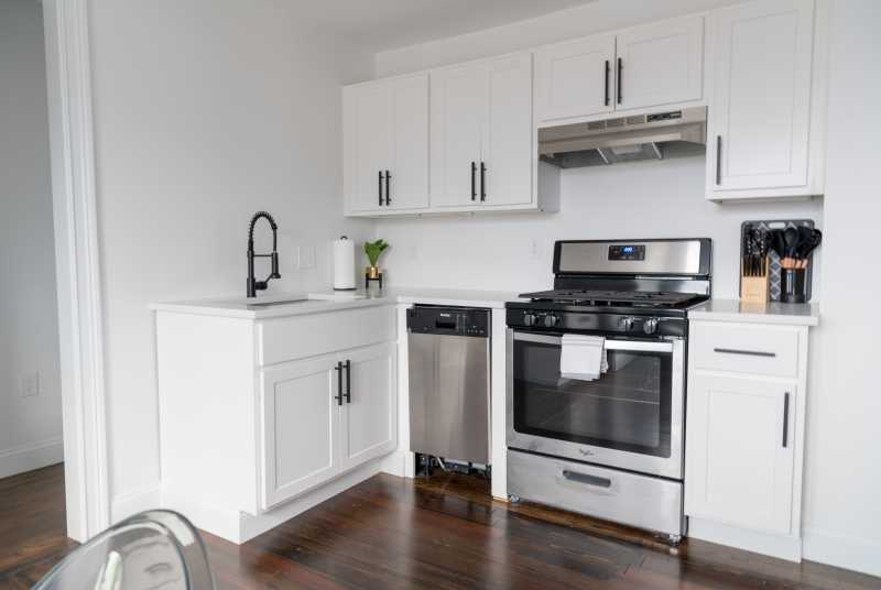 A white kitchen with stainless steel appliances.