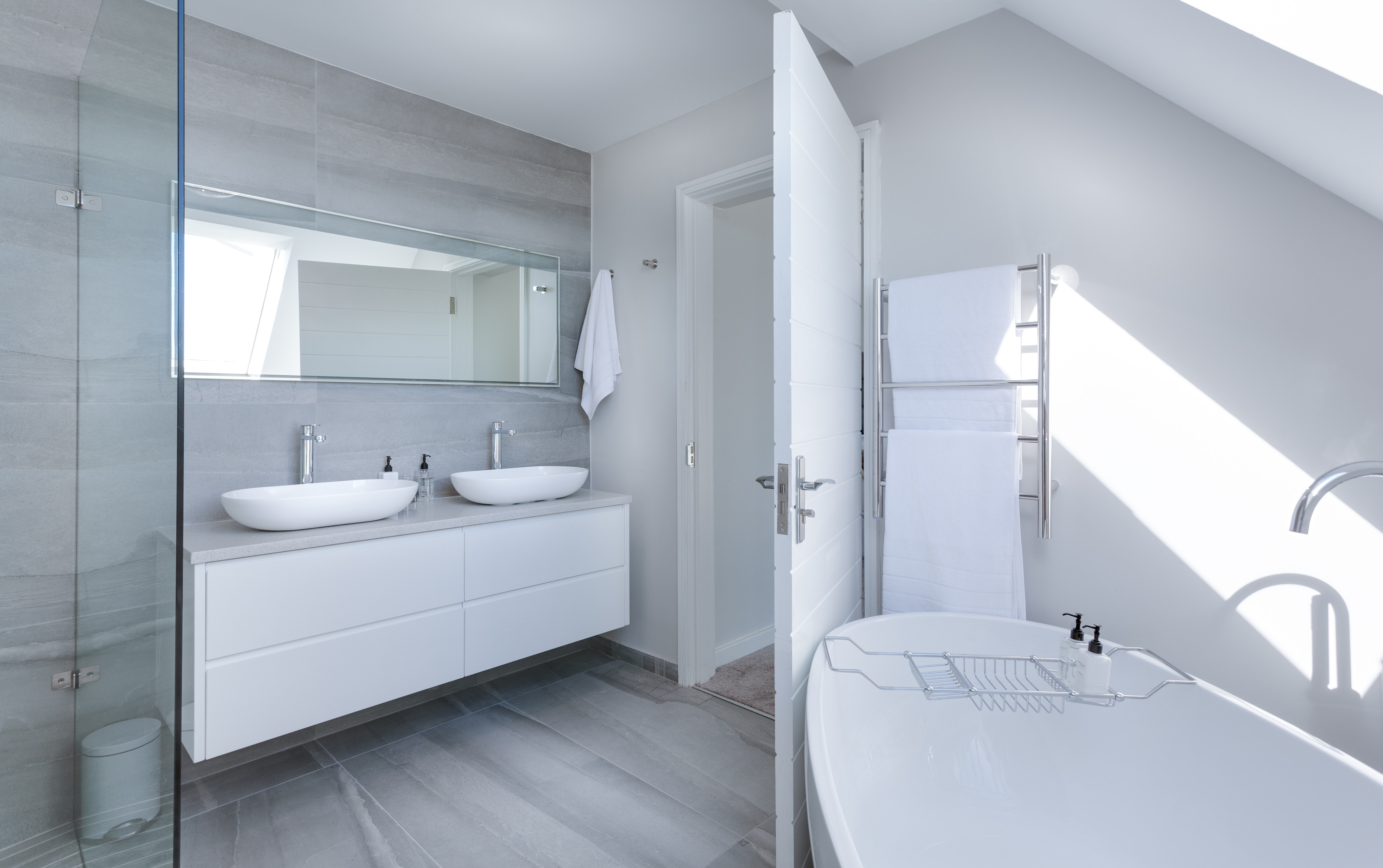 A white modern bathroom with a double sink vanity.