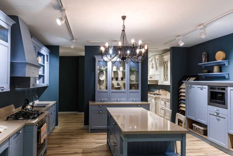 A large blue kitchen with glass front cabinets.