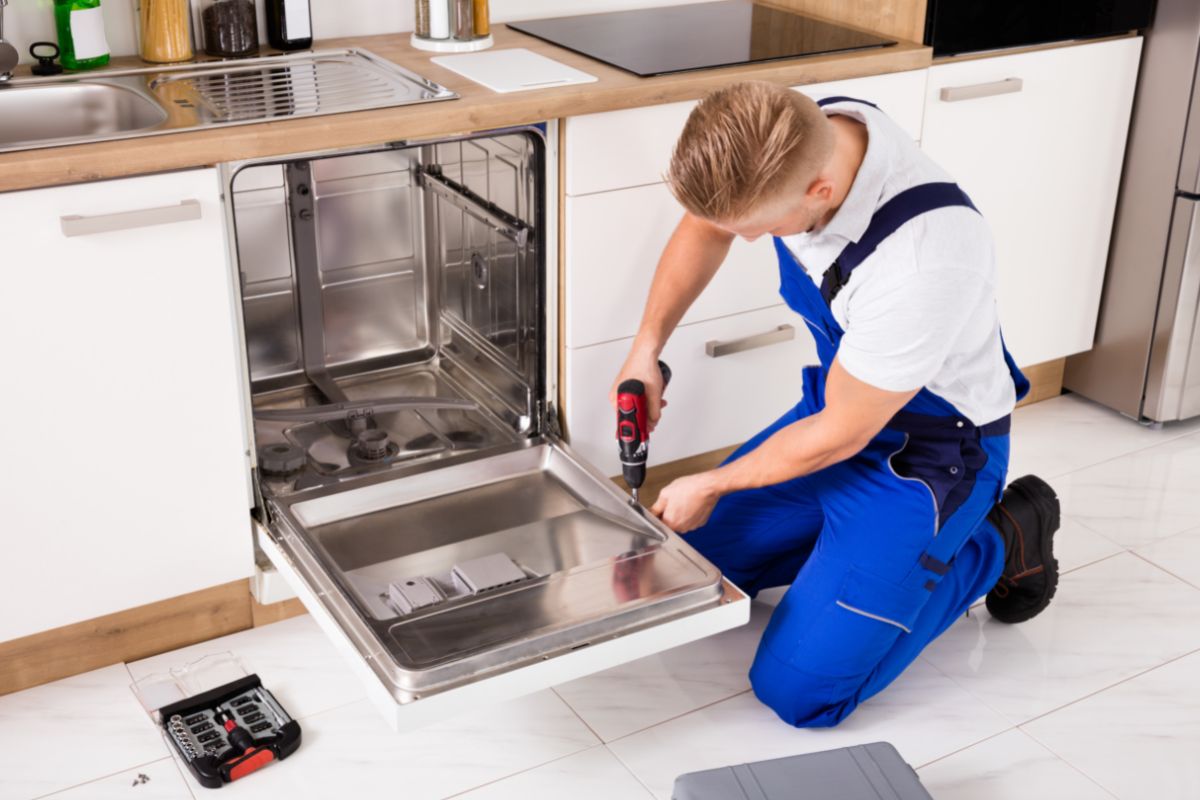 man screwing on dishwasher panel