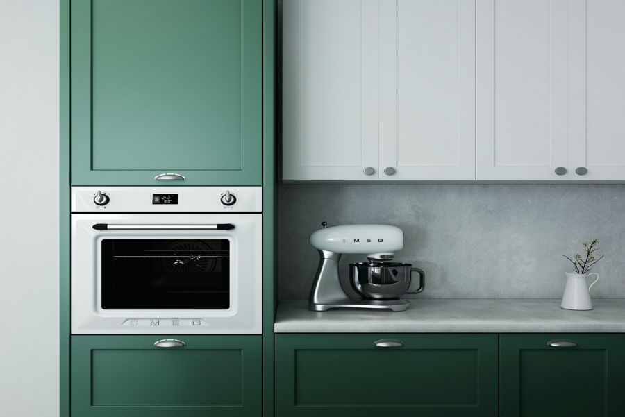 A trendy two tone kitchen utilizing dark green and white shaker cabinets.