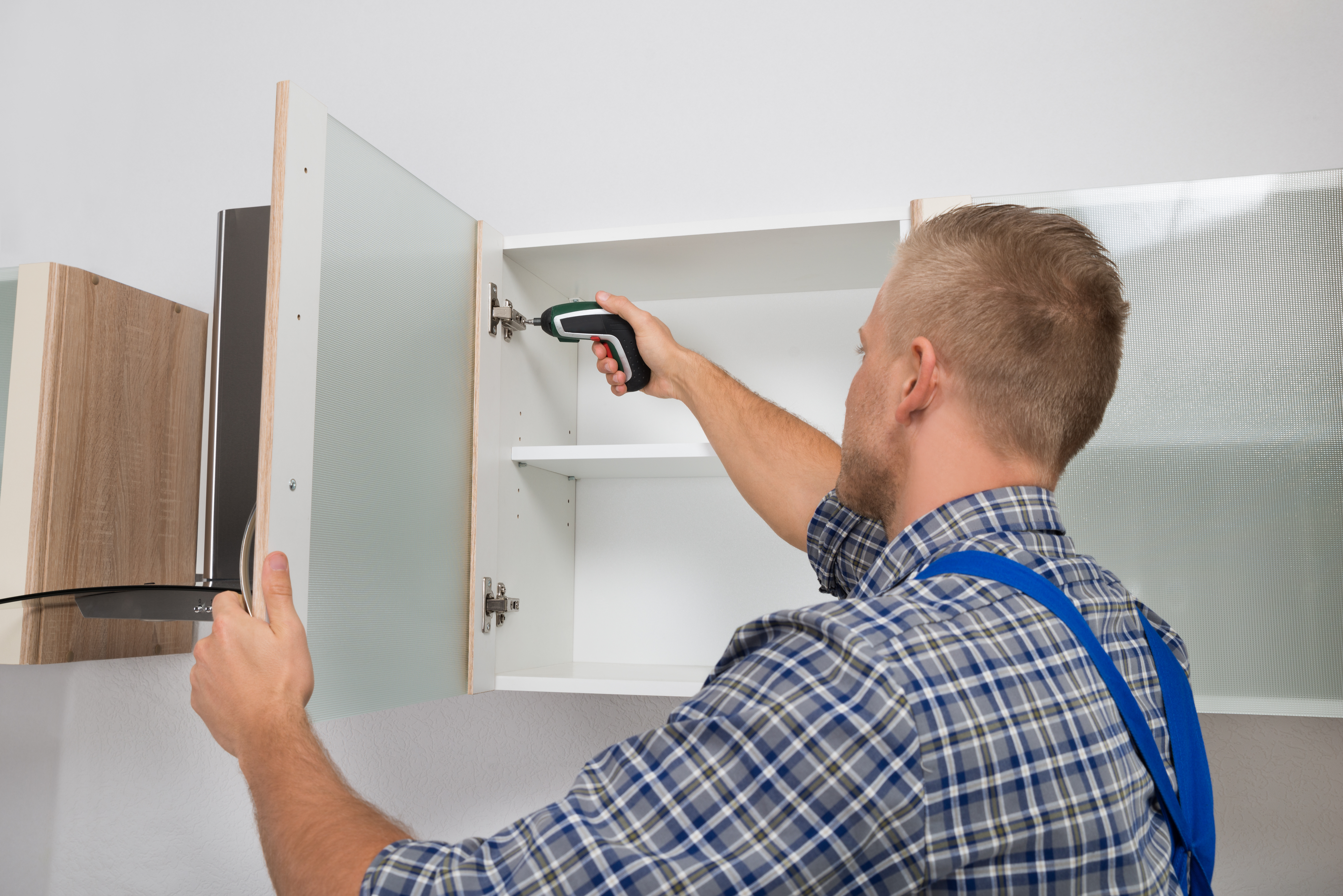 Man repairing cabinet door 