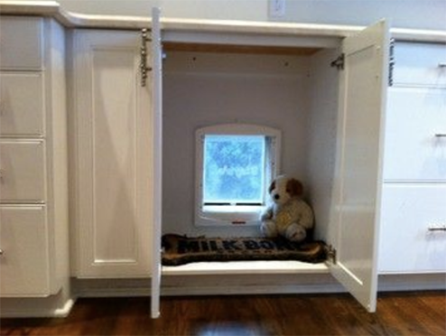 A doggy door hidden inside a base cabinet box.