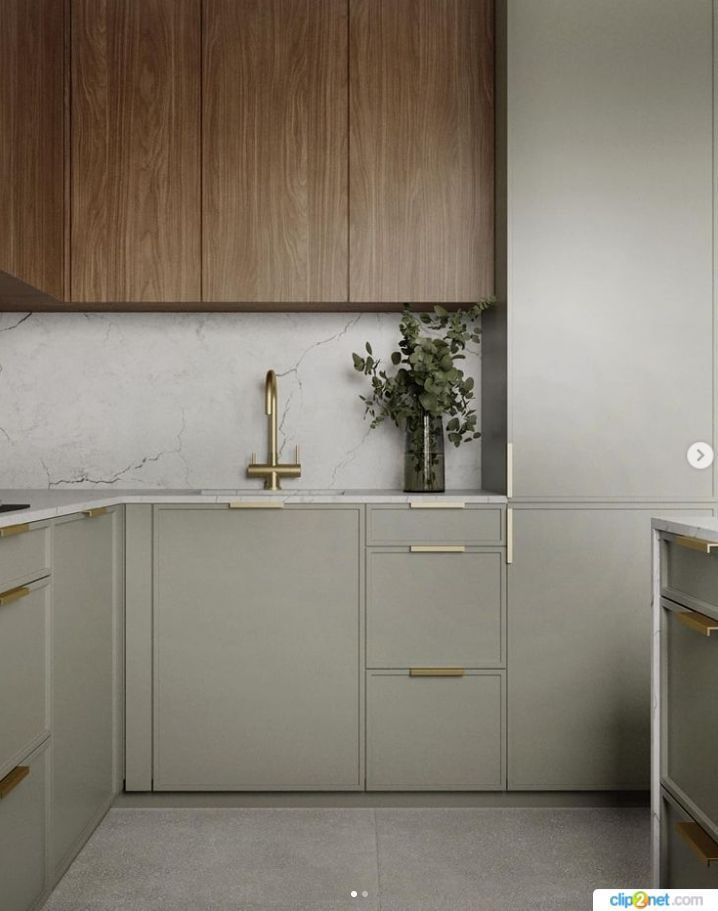 Slim shaker cabinet doors in soft sage green with wood upper cabinets, brass hardware, and modern marble backsplash.