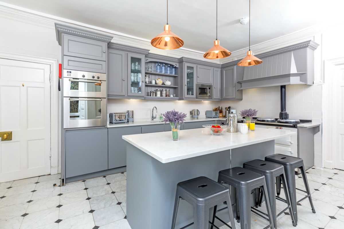 Cool grey kitchen cabinets with copper pendant lights