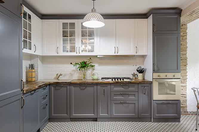 A kitchen with two tone cabinets.