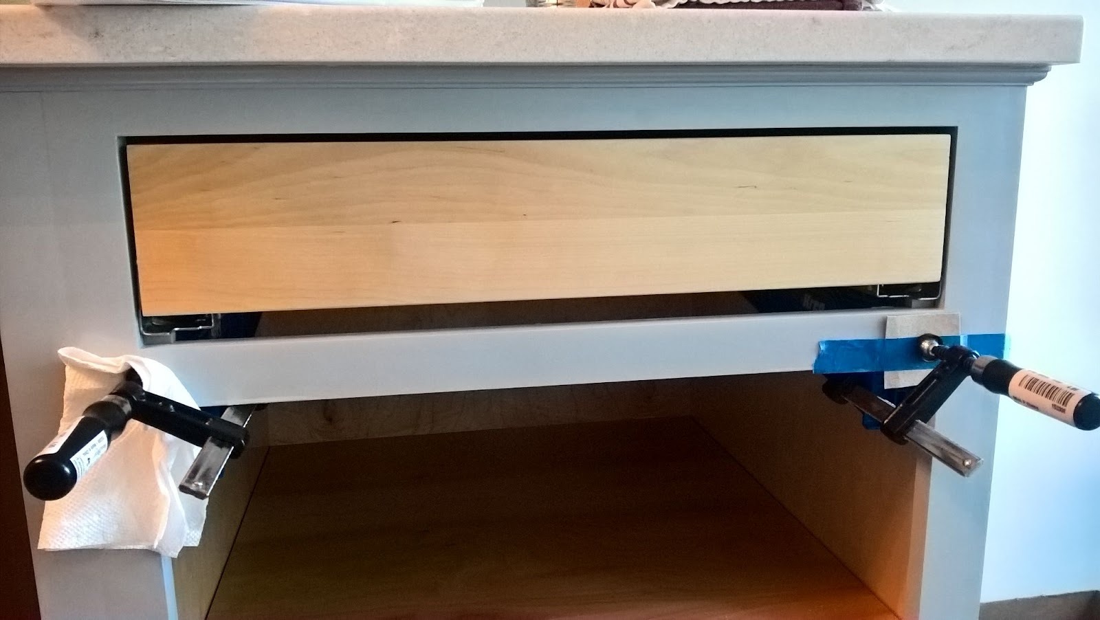 Aligning and attaching a drawer front to a newly installed drawer box