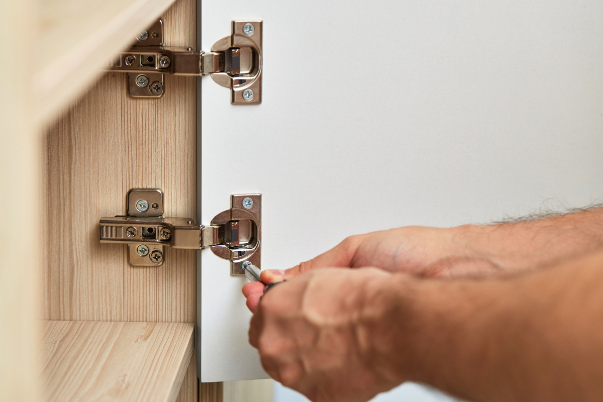 Installing replacement cabinet door hinge on cabinet frame during kitchen cabinet door installation