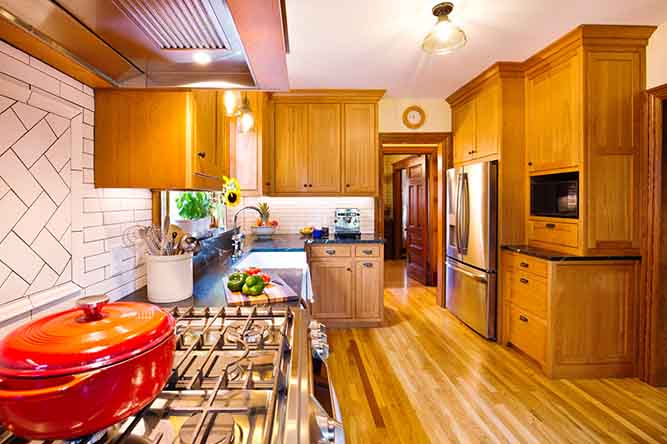 A large kitchen with natural finished adobe style kitchen cabinets.