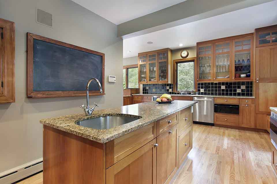 A large, open concept kitchen with natural finish shaker cabinets.