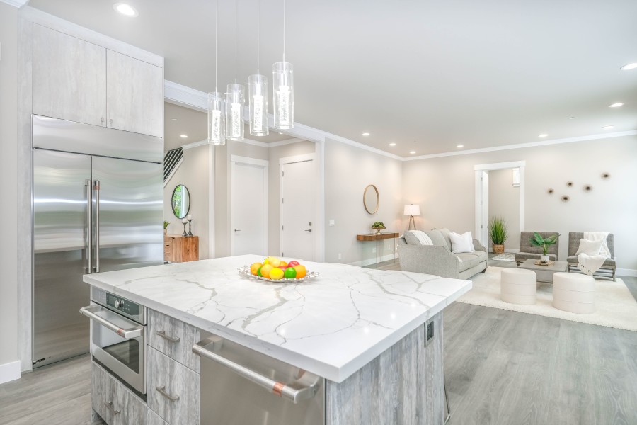 A large open plan kitchen with a marble topped kitchen island.