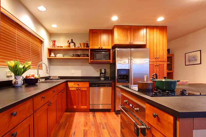 A kitchen with cherry finished shaker cabinets. 