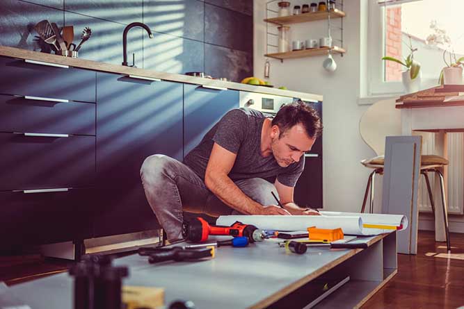 A person working on a cabinet box. 