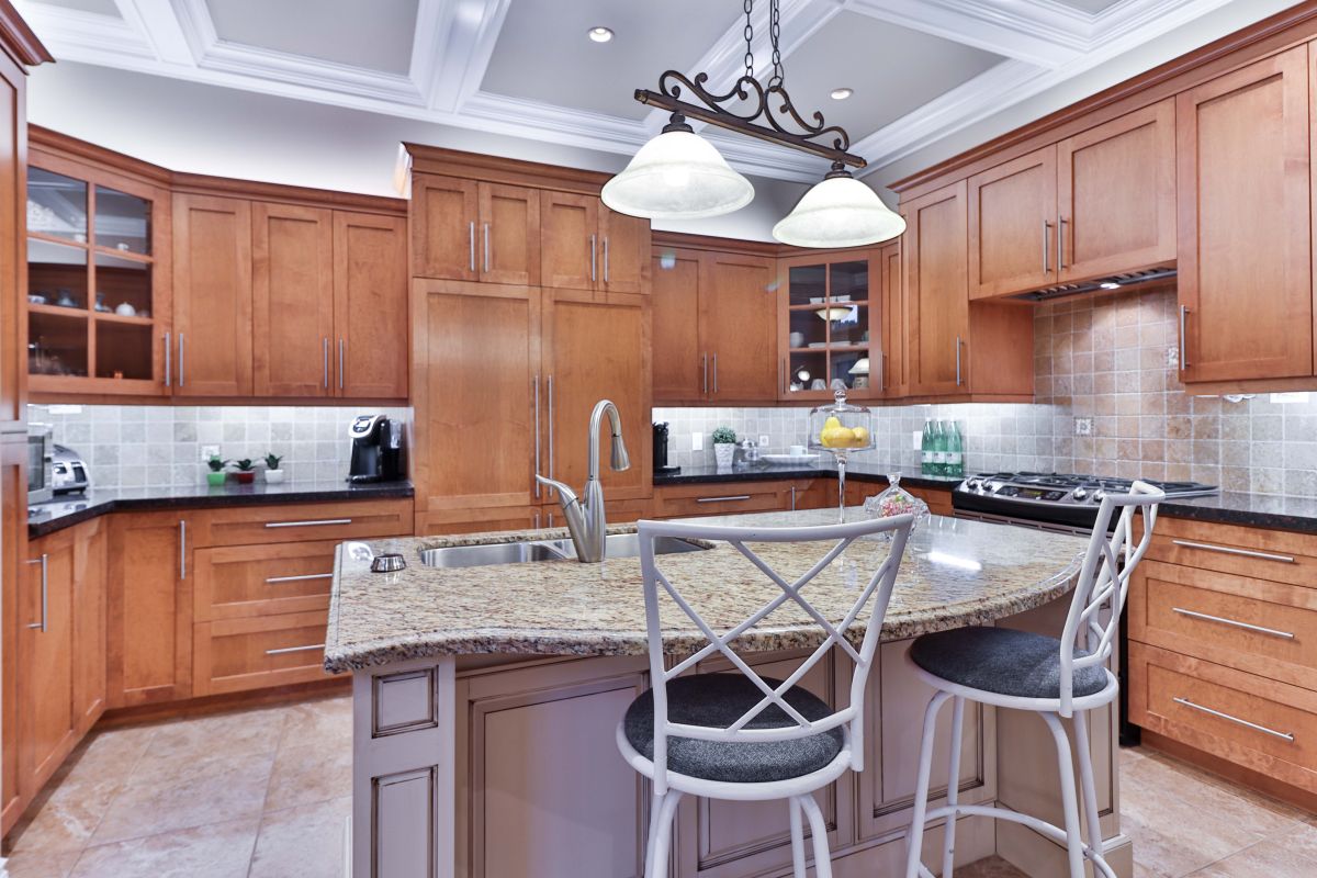 A medium sized kitchen with an ornate island and shaker style cabinets.