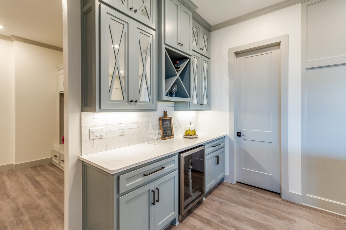 Mirrored Mullion Shaker Cabinet Doors with Built-In Wine Storage Blue shaker built-in wine bar with mirrored mullion cabinet doors, integrated wine storage, and custom cabinetry.