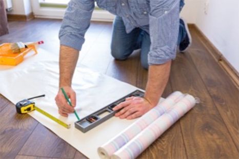 A person cutting wallpaper