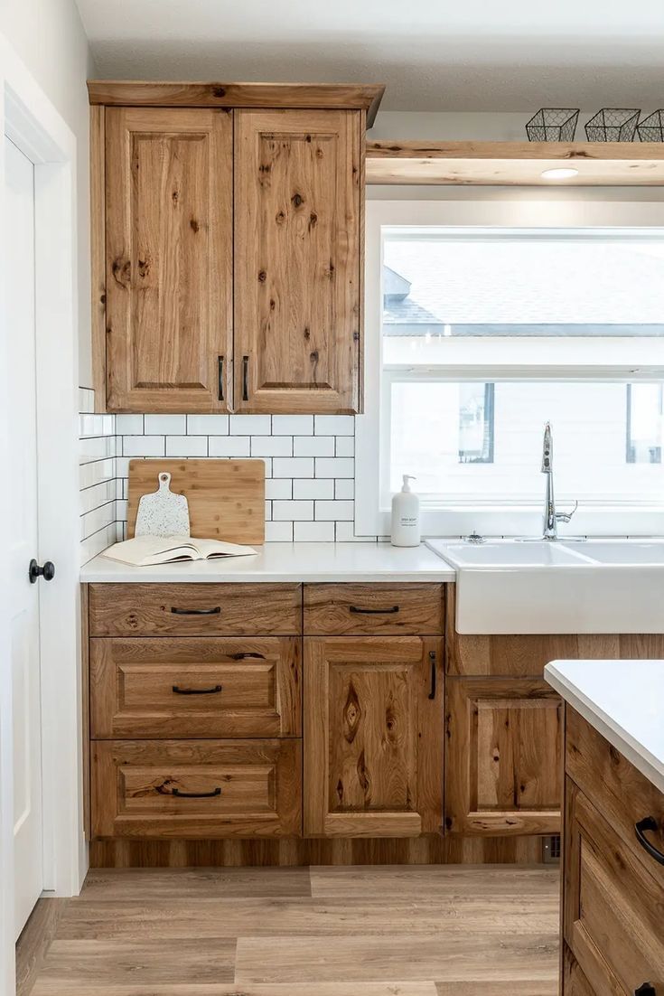 Rustic Hickory Kitchen Cabinets with White Farmhouse Sink Rustic hickory kitchen cabinets with a white farmhouse sink, subway tile backsplash, and black cabinet hardware.