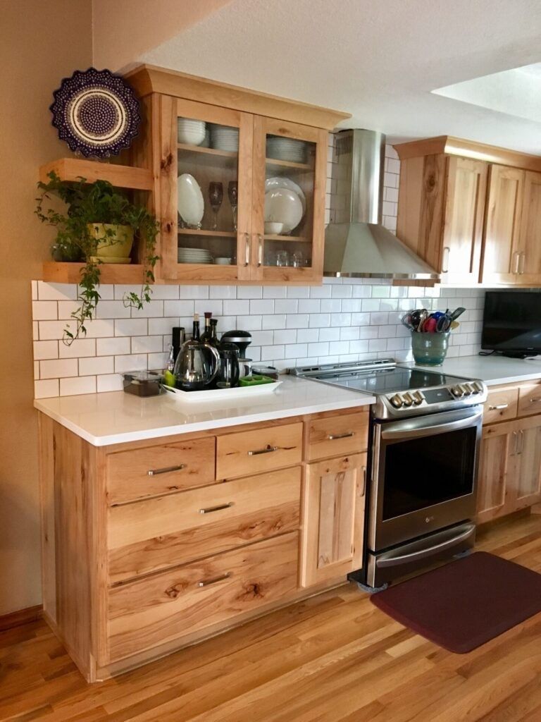 Rustic Hickory Kitchen Cabinets with Glass Display Doors Rustic hickory kitchen cabinets with glass upper cabinet doors, white quartz countertops, and a white subway tile backsplash.