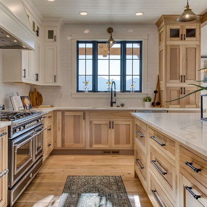 Rustic Hickory Kitchen Cabinets Paired with White Cabinetry Rustic hickory kitchen cabinets paired with white upper cabinets, quartz countertops, and black hardware in a bright kitchen.