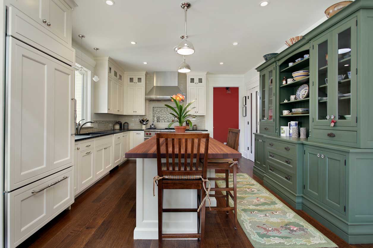 A white L-shaped kitchen with a green accent hutch and center island.