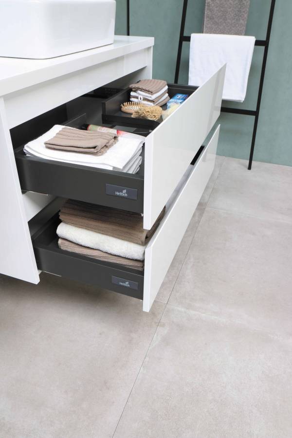 A bathroom vanity with two open drawers.