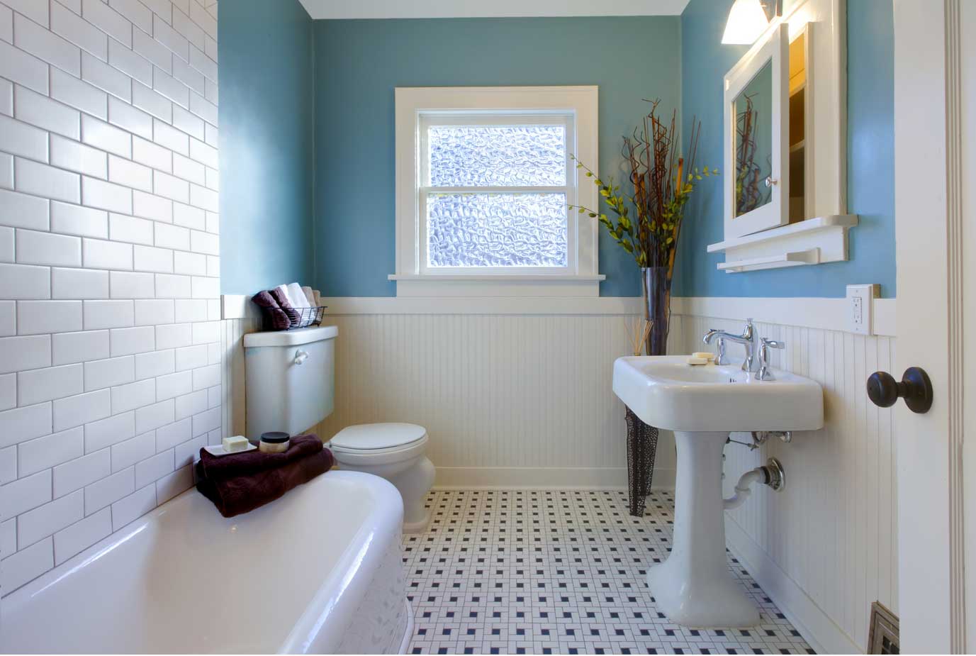 A white and blue bathroom with pedestal sink.