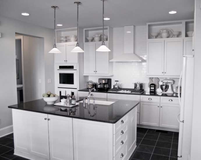 A modern kitchen with white cabinetry and contrasting floor and countertops.