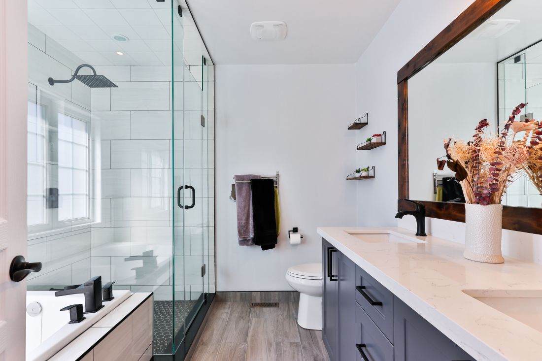 A bathroom with white painted walls and a double sink vanity. 