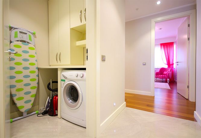 A small laundry with cabinets. 