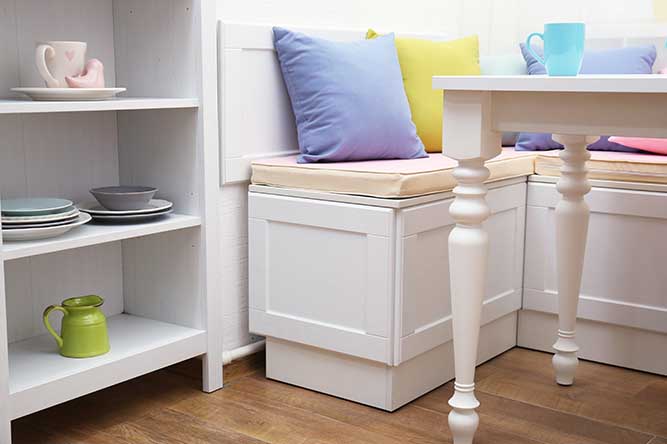 Small white breakfast nook with colorful pillows