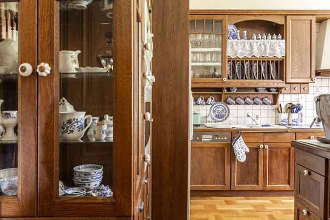 A traditionally finished kitchen with cabinets filled with china.