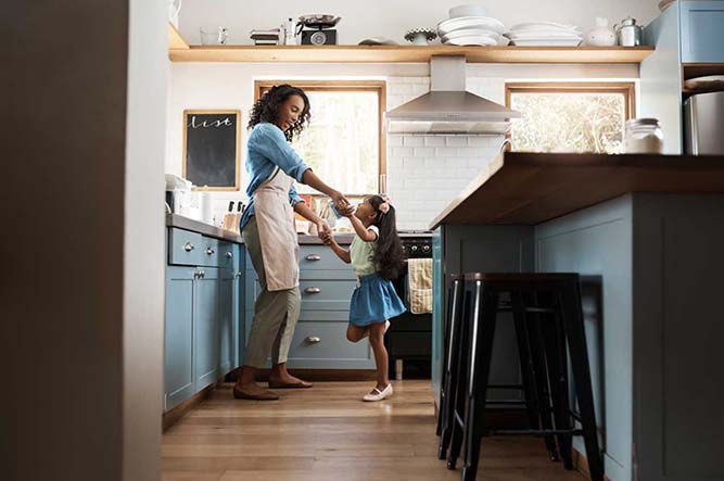 Two people dancing in a blue kitchen