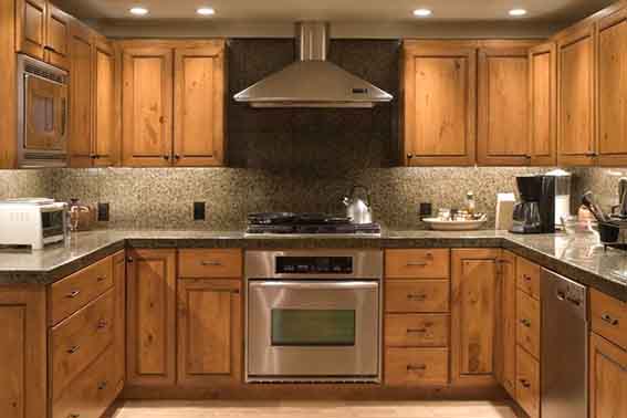 A traditional U-shaped kitchen with dark stained cabinet doors.